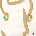 Detailaufnahme von vergoldetem Ohrring mit blauer Emaille und Zirkonia auf Display - Blaugrün