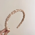 Detail of champagne gold satin pleated headband with elegant ruffled texture and silk gloss - Off-white