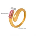 Vista macro dell'anello in acciaio placcato oro 18K con strass rosa incastonati - Numero 7 / Oro con strass rosa