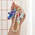 Detail van een schattige blauwe fopspeen en zuigfles met een kleurrijke beren-sleutelhanger - Licht Gouden Gesp + Ketting + Speen + Fles / Saffierblauw