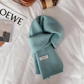Detailed texture of light blue knitted scarf with Feiding brand tag on white sheet - Light Blue