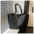 Detailed view of black tote bag with matte leather texture and stitching accents - Black