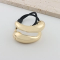 Detail eines minimalistischen Haargummis mit goldener Metallkette und schwarzem Band - Asymmetrische Gold Haarschnur