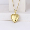 Polished gold heart locket pendant necklace displayed on a white marble block - Smooth Heart 19*23/Gold
