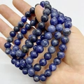 Elastic bracelet with round deep blue natural stone beads held in hand for texture detail - Old Blue Vein