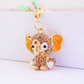 Detailed macro view of the gold elephant charm with brown rhinestones and orange enamel ears - Brown