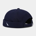 Vista dettagliata del berretto docker blu scuro con piccolo ricamo a forma di dinosauro - Regolabile / Blu navy