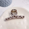 Detail of a large cream tortoiseshell hair claw clip with golden metal spring on a plate - Pink Leopard - Butterfly Buckle Straight (Approx 11.3cm)