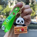 Cute panda plush keychain on orange crate with green silicone PANDA wristlet strap - Panda Gen 4 - Style 06