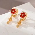 Detailansicht der goldenen Blumen-Ohrringe mit roten Kristallen und Zirkonia-Akzenten - Rot