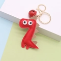 Dettaglio portachiavi a forma di dinosauro in pelle rossa con anello oro e campanellino - Rosso
