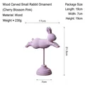 Minimalist wooden rabbit figurine in cherry blossom pink with a round base support - Flying Little Rabbit Stand / Sakura Pink