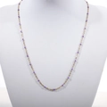 Detail of a thin gold beaded necklace featuring delicate purple enamel beads on a fine chain - Gold + Purple