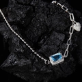 Detail of silver S925 bracelet featuring a blue rectangular gemstone and heart charm - White Gold Plated Natural Topaz
