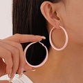 Close-up of matte pink geometric hoop earrings shown on a model for a stylish look - Pink Large Hoop