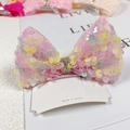 Dettaglio del fermaglio per capelli a fiocco rosa con paillettes colorate su cartoncino - Rosa Arcobaleno