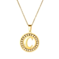 Close-up of gold-plated circular pendant with letter C and sparkling zircon stones - Letter C
