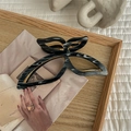 Detail of a large marble texture butterfly hair claw clip on a wooden display tray - Black+White