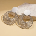Dettaglio di orecchini tondi in argento con avvolgimento in filo metallico su base di pietra - Orecchini / Argento
