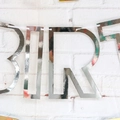 Detail of silver mirror finish Happy Birthday banner letters on white brick wall - Mirror Paper Hollow Silver