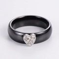 Detailed view of black ceramic heart ring featuring silver border and pavé rhinestones - US 6 / Steel