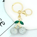 Detailed view of a gold cherry keychain featuring silver rhinestones and green leaves - Silver Rhinestone Cherry