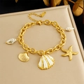 Pulsera oceánica dorada con colgantes de estrella de mar y concha sobre joyero - Estilo de Amuleto de Océano Dorado (B1755)