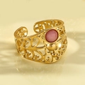 Detalle macro de anillo abierto dorado con patrones de filigrana y piedra rosa redonda - Piedra rosa redonda / Banda de oro hueca / Rosa