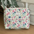 Detailansicht der gesteppten Vintage-Kosmetiktasche mit Blumenmuster und Markenetikett - Handtasche - Blumenranke