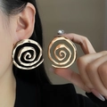 Detailed view of oversized golden spiral textured earrings worn by a model - E3350-12 Multi-Circle Spiral Style / Gold
