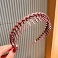 Brown matte wave headband with non-slip teeth for women holding by a hand - Wine Red
