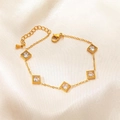 Detail of gold bracelet with five square clear zircons on elegant beige satin fabric - White Rhinestone Square Block Style