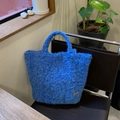 Borsa tote in peluche blu brillante con ciondolo a cuore su sedia in pelle scura - Blu