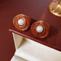 Primer plano de pendientes de flores de ámbar vintage con perlas en estuche rojo - Marrón