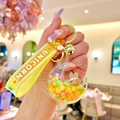 Detail of moon-shaped acrylic keychain with yellow liquid sand, rabbit and gold bell - Yellow Colorful Bead Star Moon Rabbit