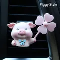 Detail of pink pig car vent clip with a blue bow and windmill on a black air vent - Pink Pig