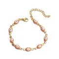 Golden Evil Eye bracelet featuring pink enamel charms and a polished metal chain - Bracelet / Oval Pink