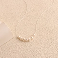 Minimalist silver necklace featuring seven graduated white freshwater pearls in an arc - 7-Pearl Curved Design / Silver