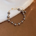 Adjustable French retro bracelet with dark grey pearls and golden metallic spacer beads - Black Pearl Bracelet
