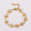 Primer plano de una pulsera dorada con estrellas y cierre de langosta, acabado pulido - Dorado
