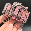 Detail van roze rhodoniet kristallen haarkam met zilveren maan en ster hanger versiering - Rhodoniet