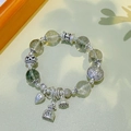 Ethnic silver bracelet with green ghost crystal beads and a lucky fortune bag charm - 12mm Green Ghost: Six-Syllable Mantra Lotus Fortune Bag