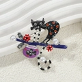 Macro view of cartoon black cat brooch with enamel details, pearls and tiny fish tank - Black Cat with Fish Tank
