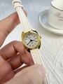 Close-up of elegant gold case ladies watch with white leather strap and Roman numerals - White Strap