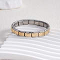 Détail d'un bracelet italien en acier inoxydable avec maillons fleuris dorés - Bicolore (Or & Argent)