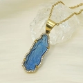 Detail of 18k gold Virgin Mary pendant with blue glass and crystals on beige silk - Transparent Blue