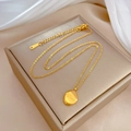 Primer plano de collar dorado de acero inoxidable con colgante ovalado en exhibidor - Estilo Grabado You are adorable / Dorado