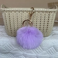 Light purple faux rabbit fur keychain with gold ring on a beige storage basket - Taro Purple