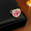 Macro view of a silver heart-shaped ring with a pink gemstone on a black leather box - Heart Halo Style / Pink