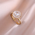 Adjustable golden sunflower ring with sparkling cubic zirconia on pink silk background - Sunflower Ring / Gold